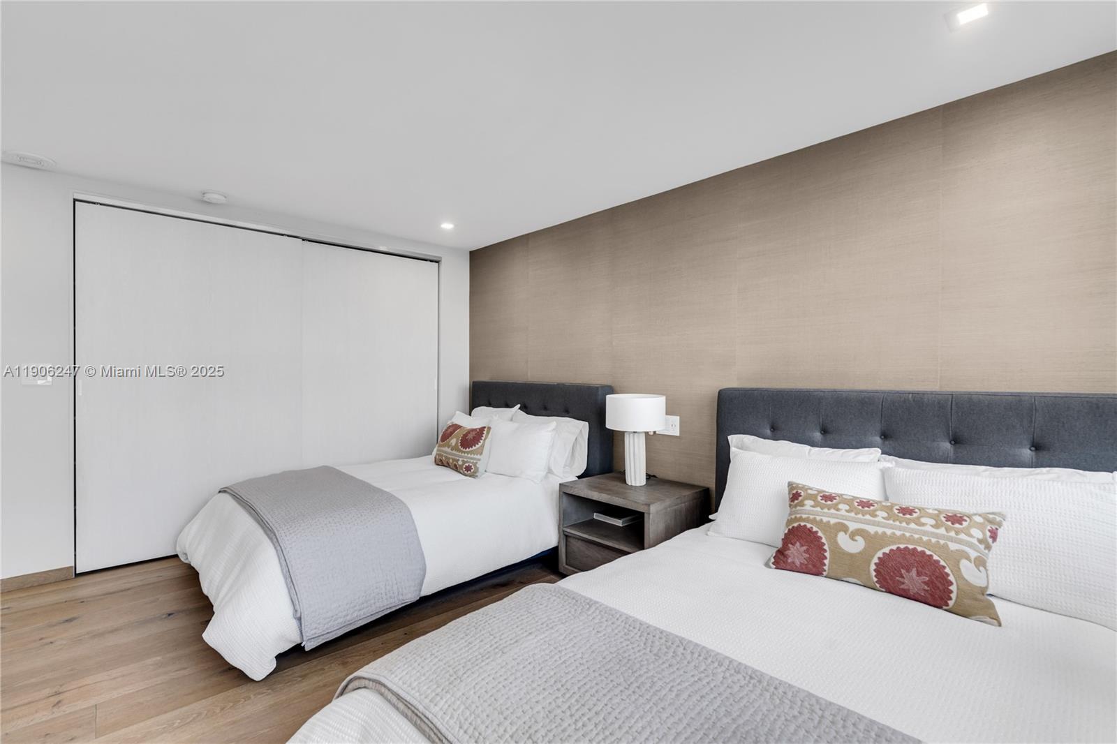 3 Grove Isle Drive, Unit C1710 Miami, FL 33133 - Photo 24 of 37 a bedroom with two beds and wooden floor