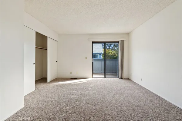 an empty room with windows and closet