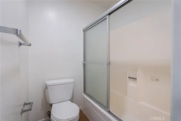 a white toilet sitting next to a bath tub