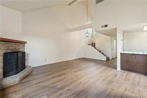 a view of a livingroom with wooden floor and a fireplace