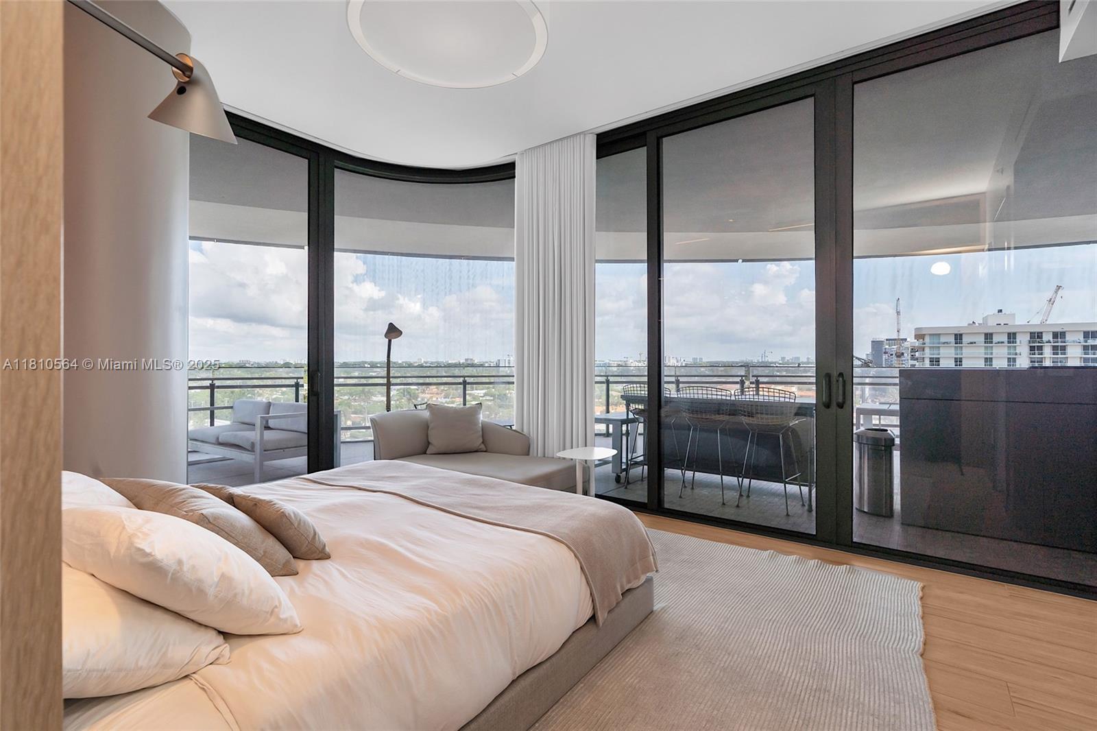 8701 Collins Avenue, Unit 905 Miami Beach, FL 33154 - Photo 32 of 80 a bedroom with a large window and a bed