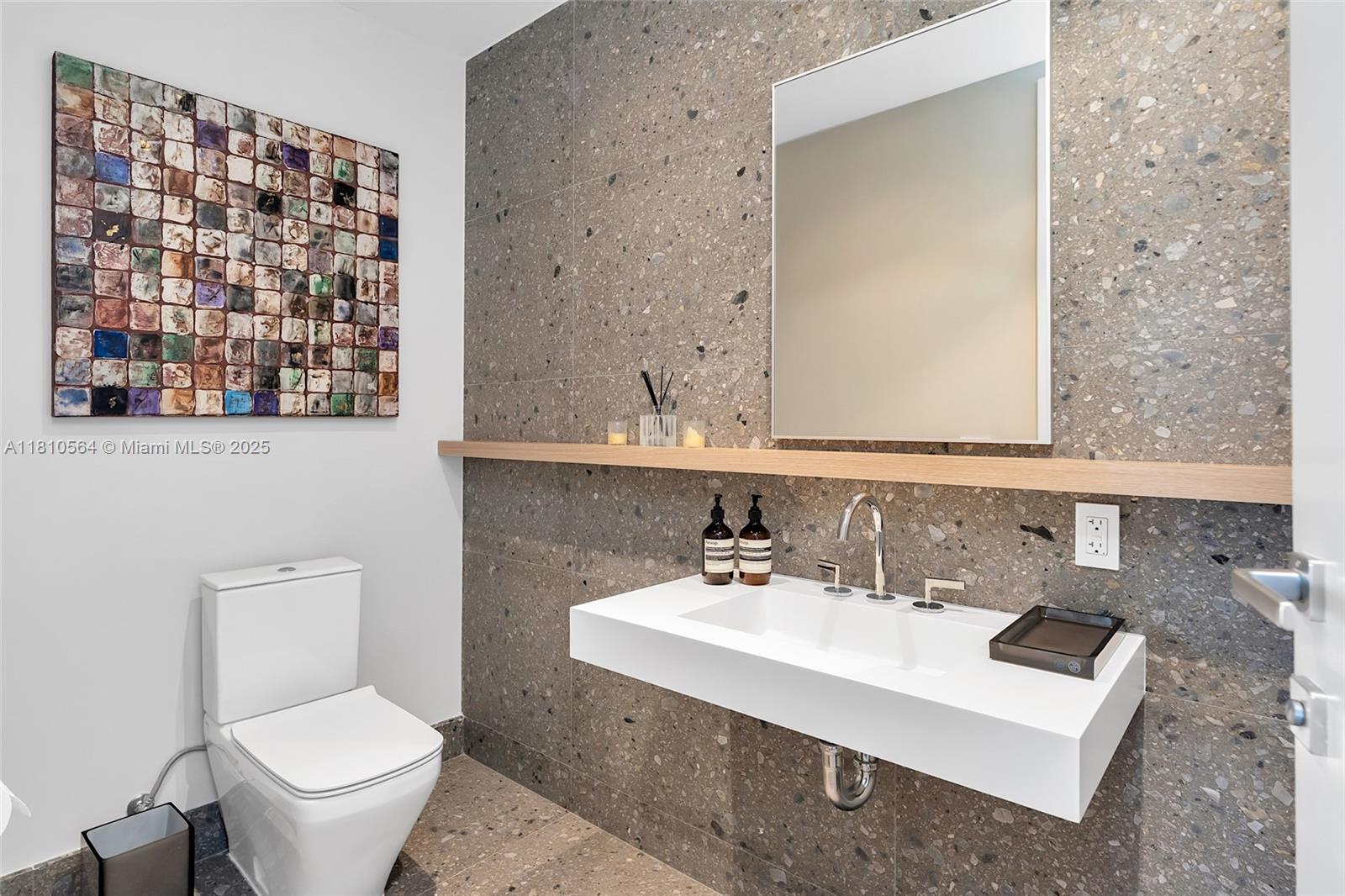 8701 Collins Avenue, Unit 905 Miami Beach, FL 33154 - Photo 45 of 80 a bathroom with a sink a toilet and a mirror