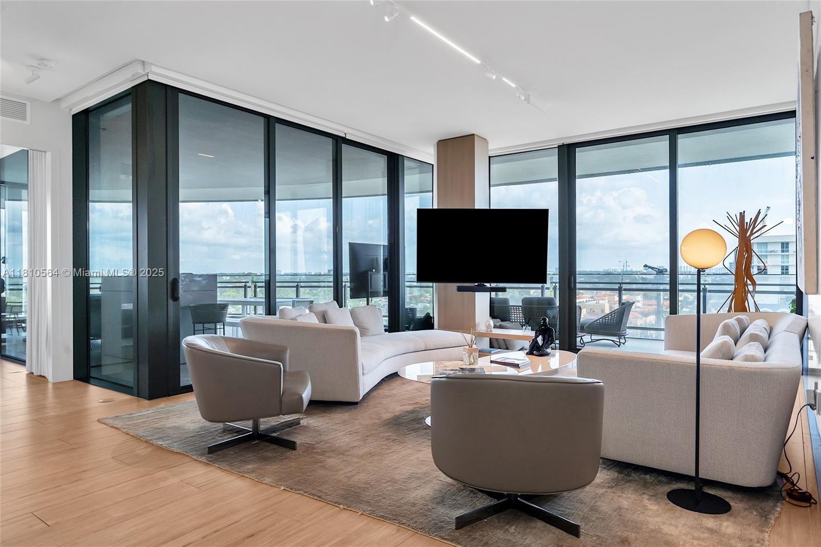 8701 Collins Avenue, Unit 905 Miami Beach, FL 33154 - Photo 5 of 80 a living room with furniture and a flat screen tv