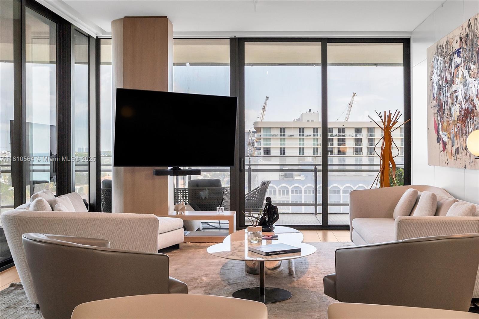 8701 Collins Avenue, Unit 905 Miami Beach, FL 33154 - Photo 7 of 80 a living room with couches a coffee table and a flat screen tv