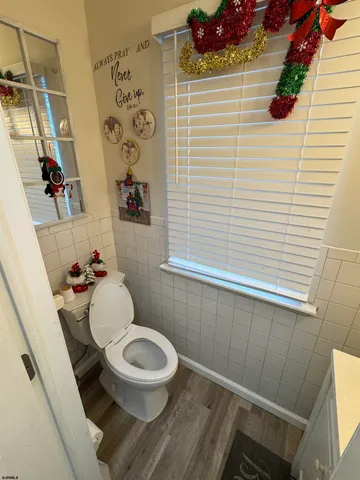 a white toilet sitting next to a white sink and vanity