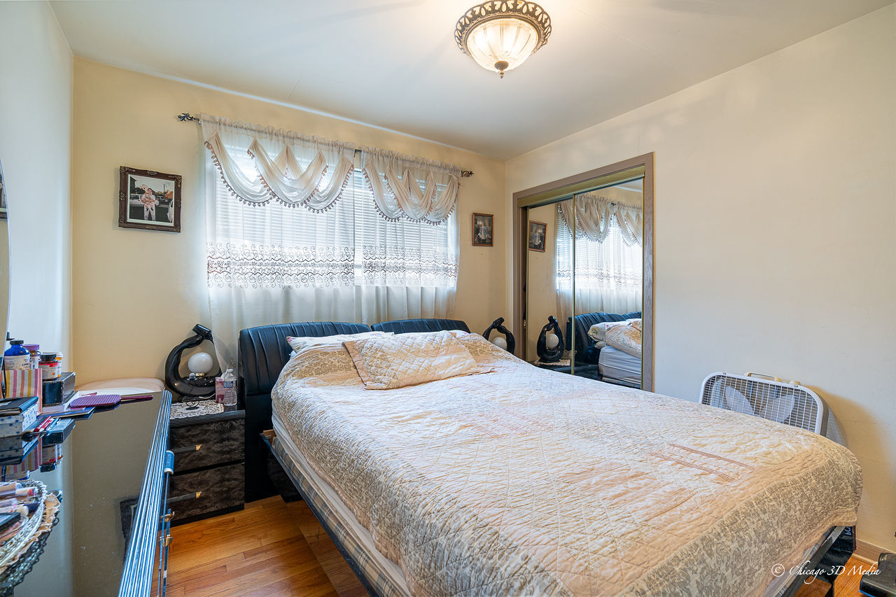 5949 North Odell Avenue, Unit 2E Chicago, IL 60631 - Photo 7 of 12 a bedroom with a bed and a chandelier