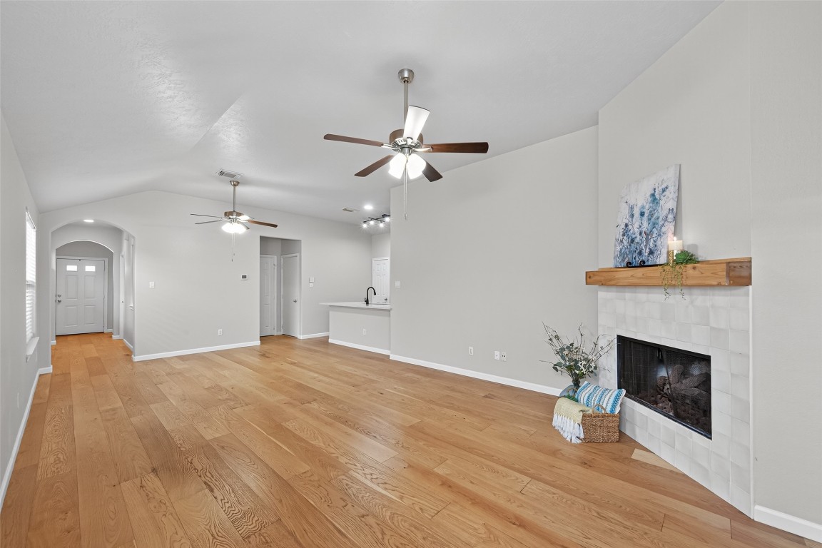 2910 Crescent Bend Road Spring, TX 77388 - Photo 23 of 35 Re-enter your open living area from the primary suite and take in the view—your beautiful kitchen, the comfort of two ceiling fans, and the charm of the arched doorway leading to the front hall. The space simply feels good!