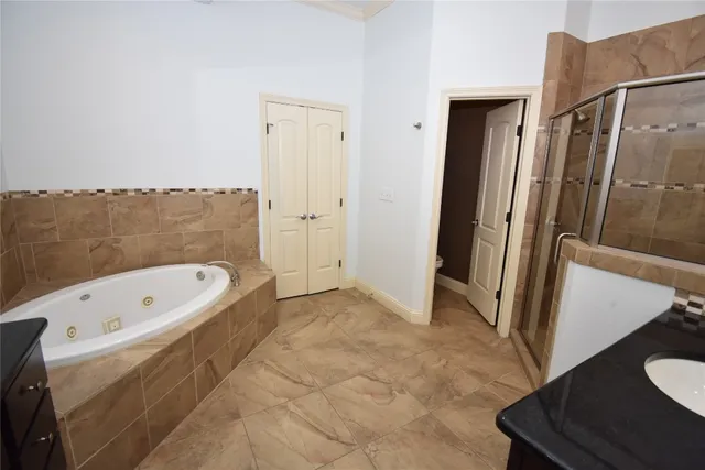 a bathroom with a tub a sink and a large mirror