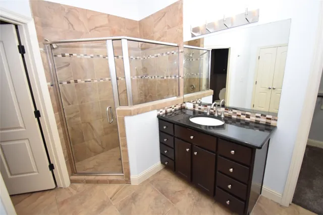 a bathroom with a shower sink and mirror
