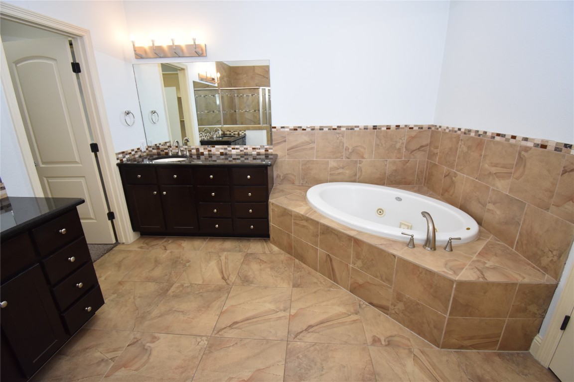 12105 Terraza Circle, Unit 67 Austin, TX 78726 - Photo 19 of 30 a bathroom with a tub sink and mirror