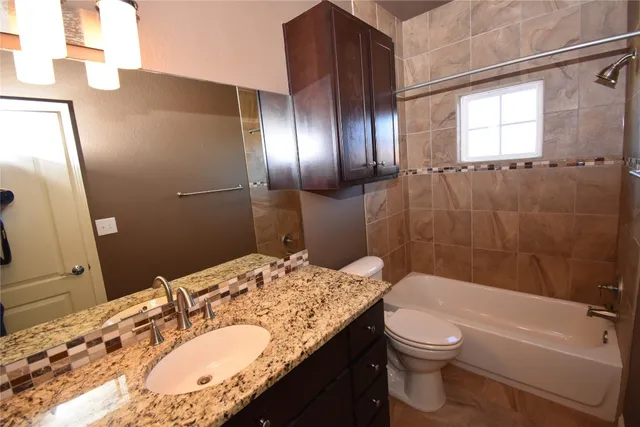 a bathroom with a granite countertop sink toilet and shower