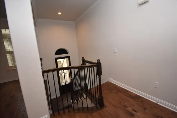 a view of a hallway with wooden floor and staircase