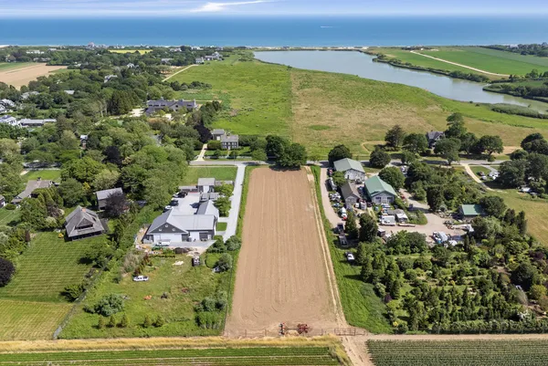 an aerial view of residential houses with outdoor space and lake view