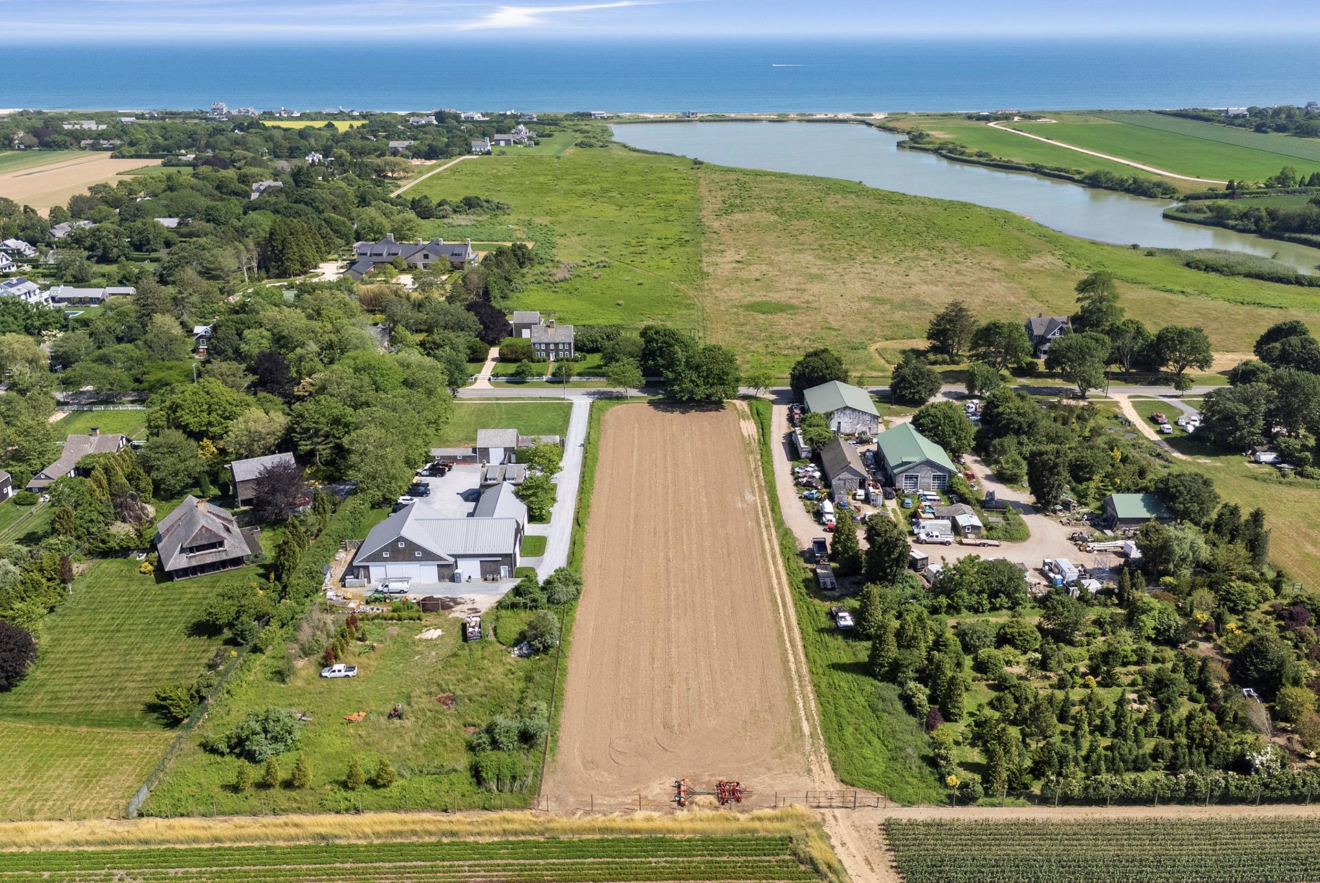 an aerial view of residential houses with outdoor space and lake view