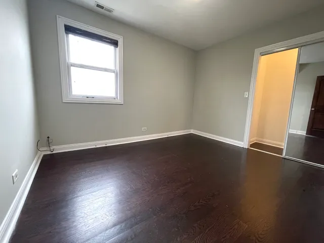 a view of a room with wooden floor and a window