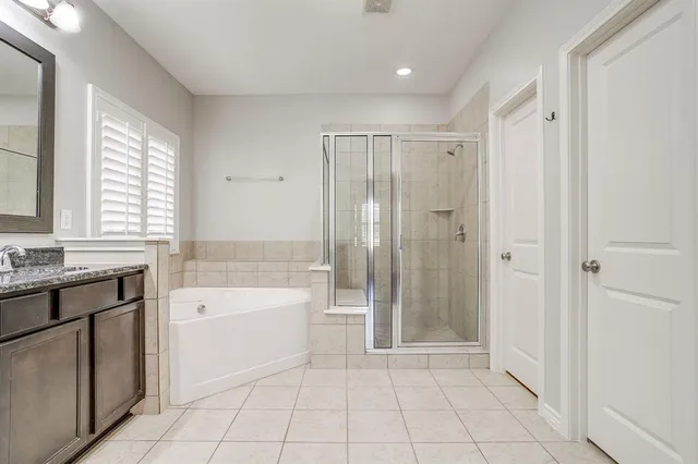 a spacious bathroom with a granite countertop sink a toilet and shower