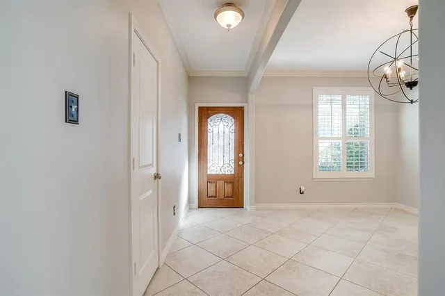 an empty room with wooden floor chandelier fan and windows
