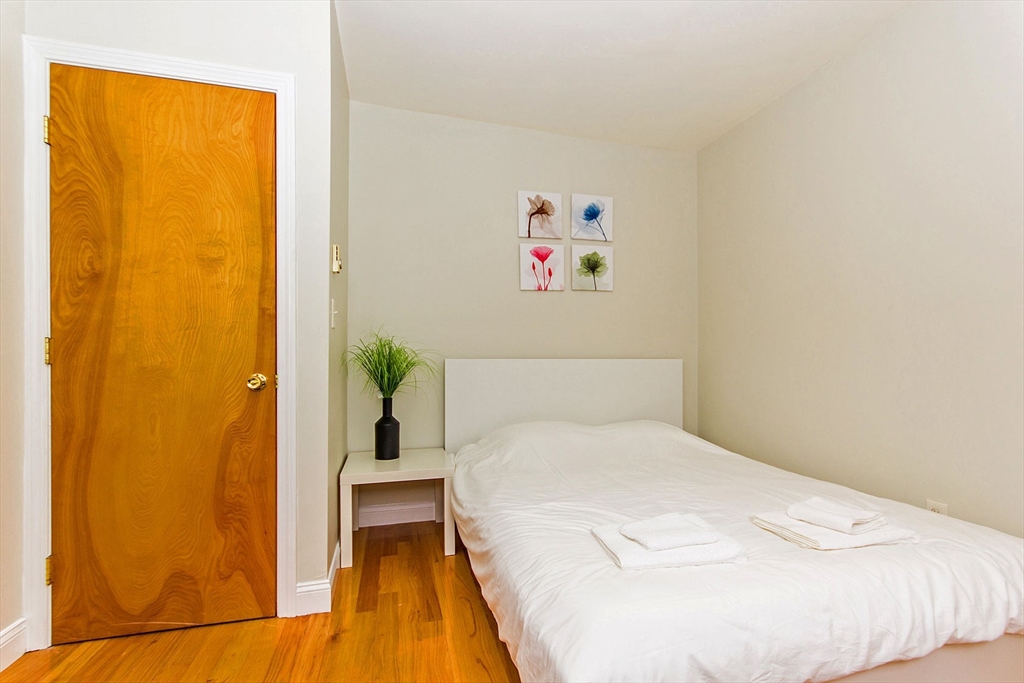 106 Tyler Street Boston, MA 02111 - Photo 13 of 16 a bedroom with a bed and a window