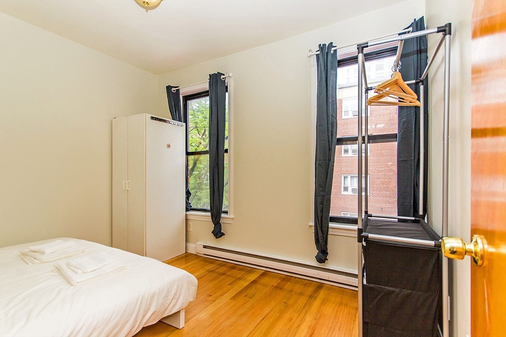 106 Tyler Street Boston, MA 02111 - Photo 14 of 16 a bedroom with a bed and a window