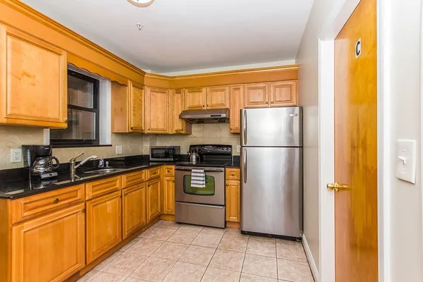 a kitchen with stainless steel appliances granite countertop a refrigerator and a sink