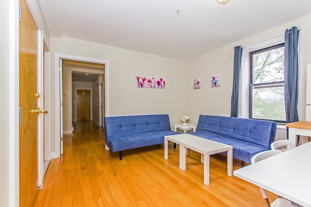 106 Tyler Street Boston, MA 02111 - Photo 10 of 16 a living room with furniture and a wooden floor