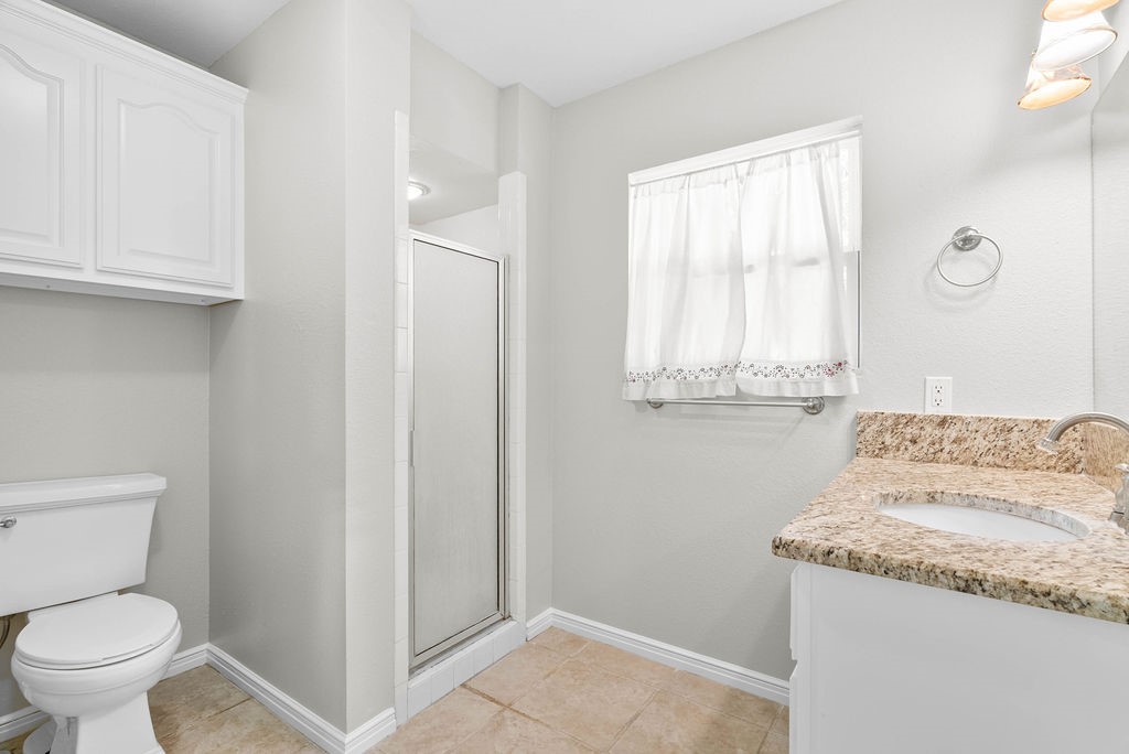 1931 North Fulton Beach Road Rockport, TX 78382 - Photo 32 of 40 a bathroom with a granite countertop sink and a toilet