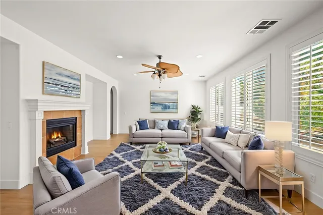 a view of a hallway to an empty room with wooden floor and a window