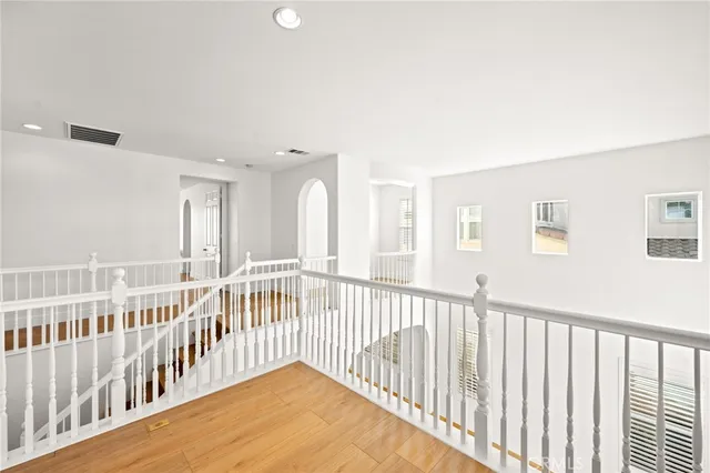 an empty room with chandelier fan and windows
