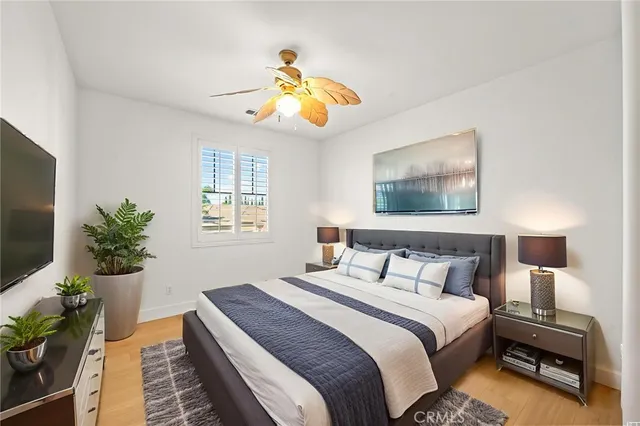 a spacious bedroom with a bed and a flat screen tv