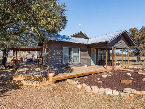 a front view of house with yard outdoor seating and barbeque oven