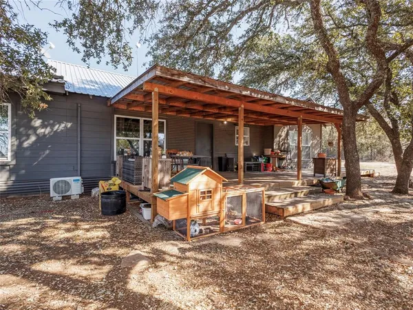 a view of a chair and table in backyard of the house