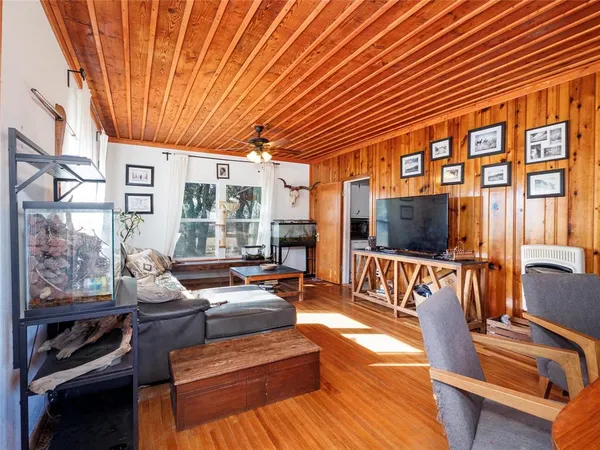 a living room with furniture a flat screen tv and floor to ceiling window