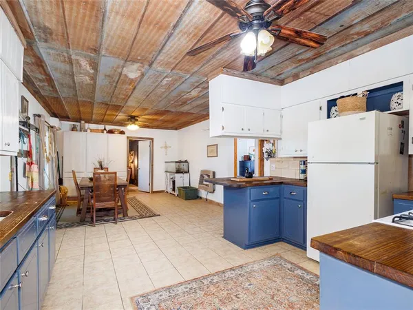 a living room with furniture and a refrigerator