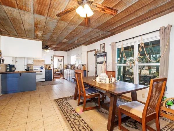 a dining hall with stainless steel appliances kitchen island granite countertop a dining table and chairs with the view of kitchen