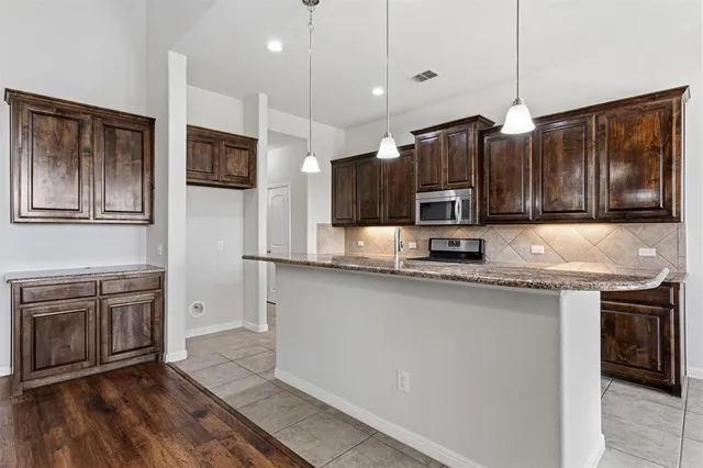 a kitchen with stainless steel appliances granite countertop a sink stove and cabinets