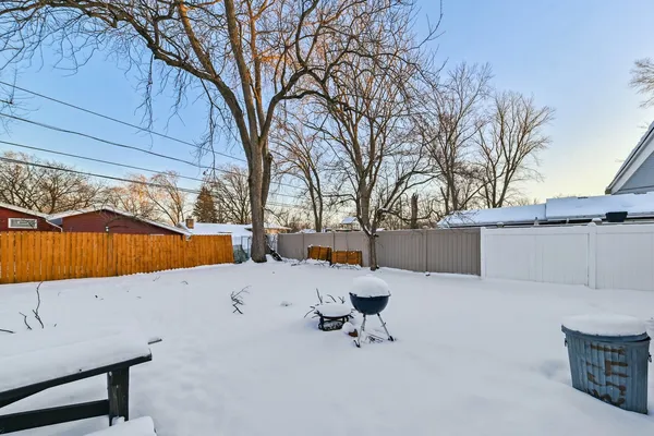 a view of backyard with a table and chairs under an umbrella
