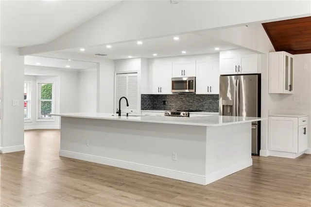 a kitchen with stainless steel appliances a refrigerator sink and microwave