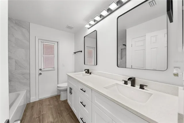 a bathroom with a double vanity sink mirror and