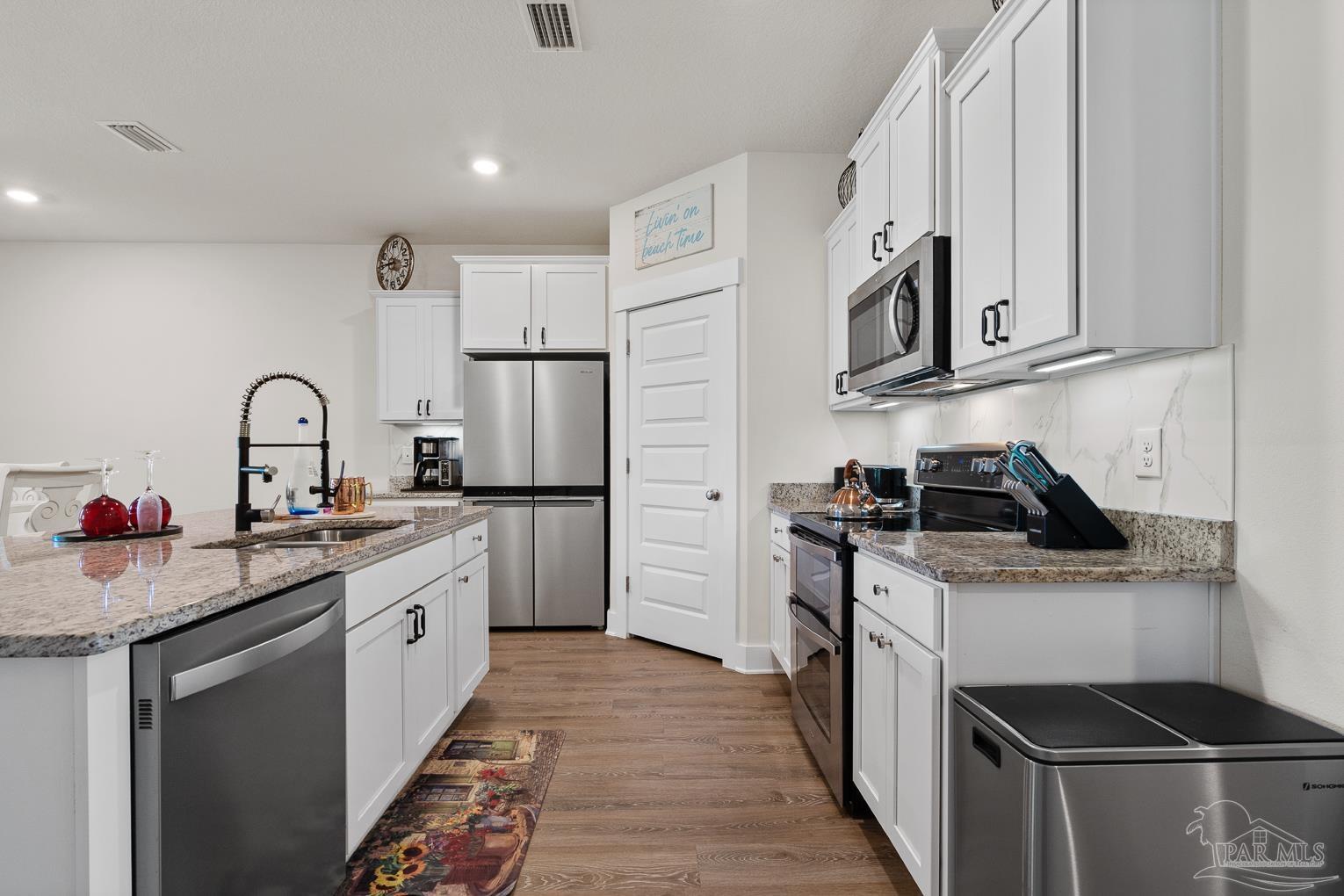 5773 Danbury Boulevard Pace, FL 32571 - Photo 11 of 34 a kitchen with stainless steel appliances granite countertop a stove sink and cabinets