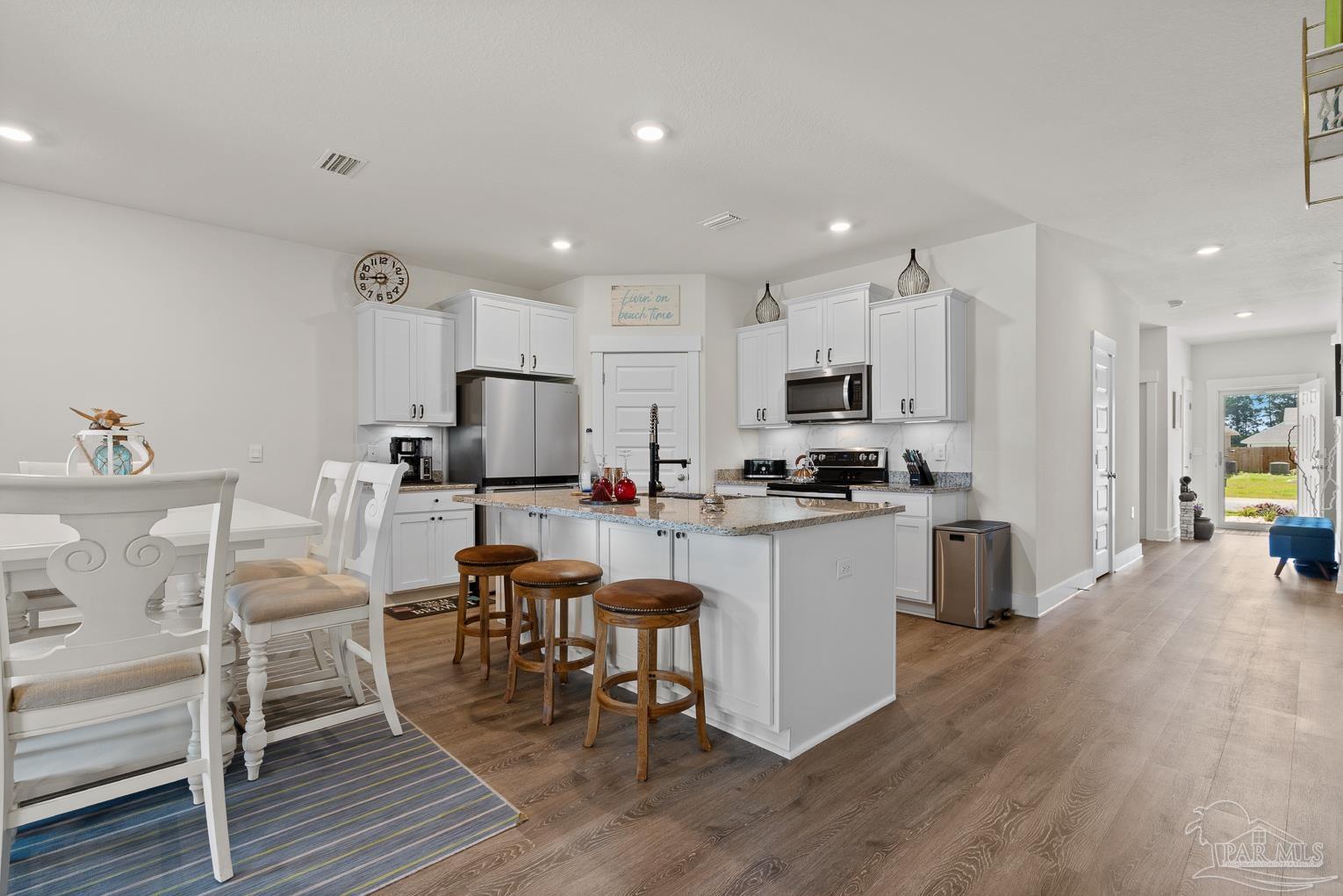 5773 Danbury Boulevard Pace, FL 32571 - Photo 12 of 34 a kitchen with a dining table chairs appliances and cabinets