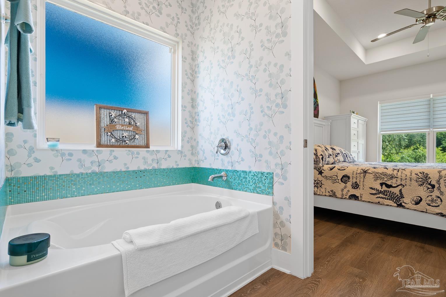 5773 Danbury Boulevard Pace, FL 32571 - Photo 17 of 34 a bathroom with a bathtub and a window