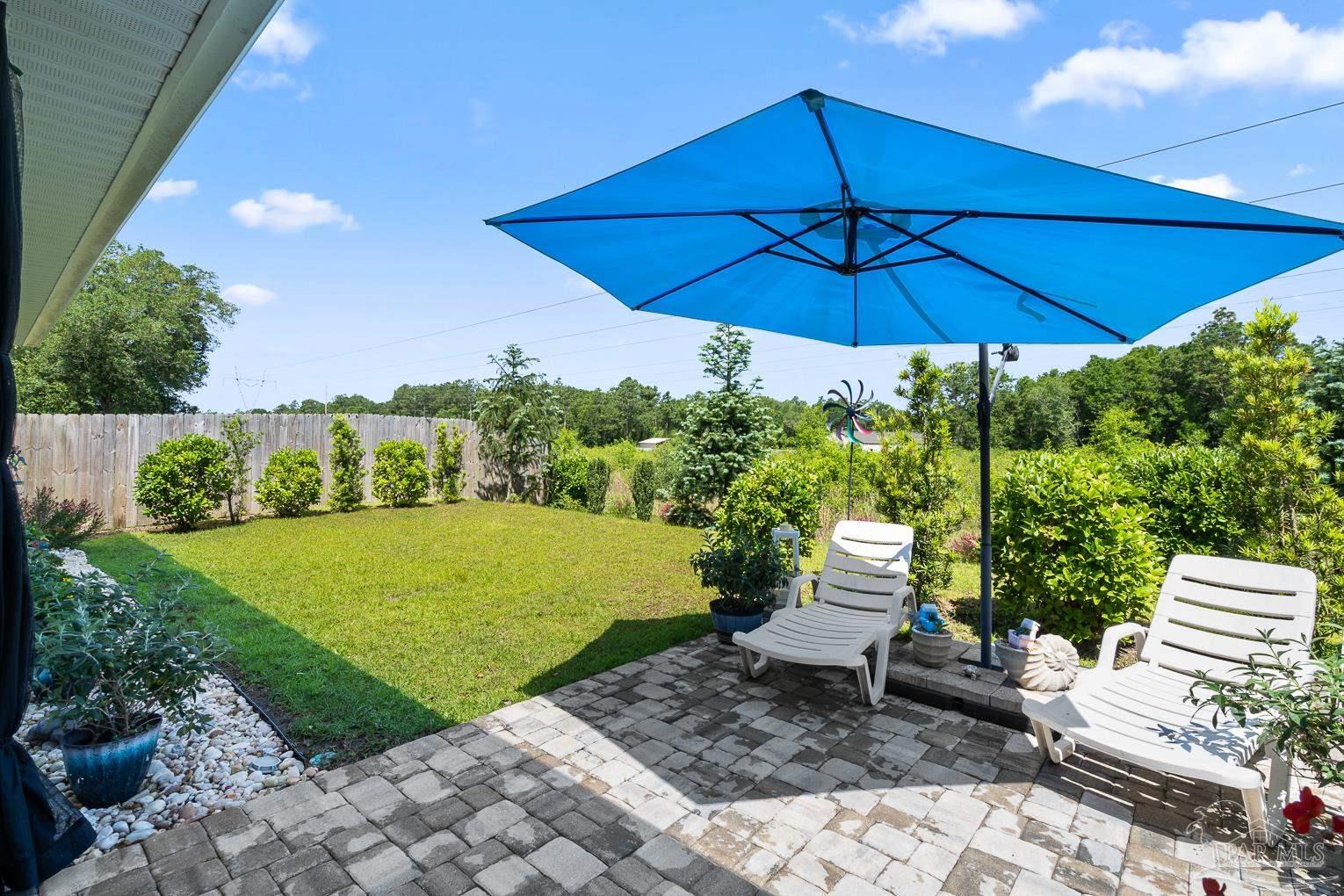 5773 Danbury Boulevard Pace, FL 32571 - Photo 28 of 34 a view of a table and chairs under an umbrella