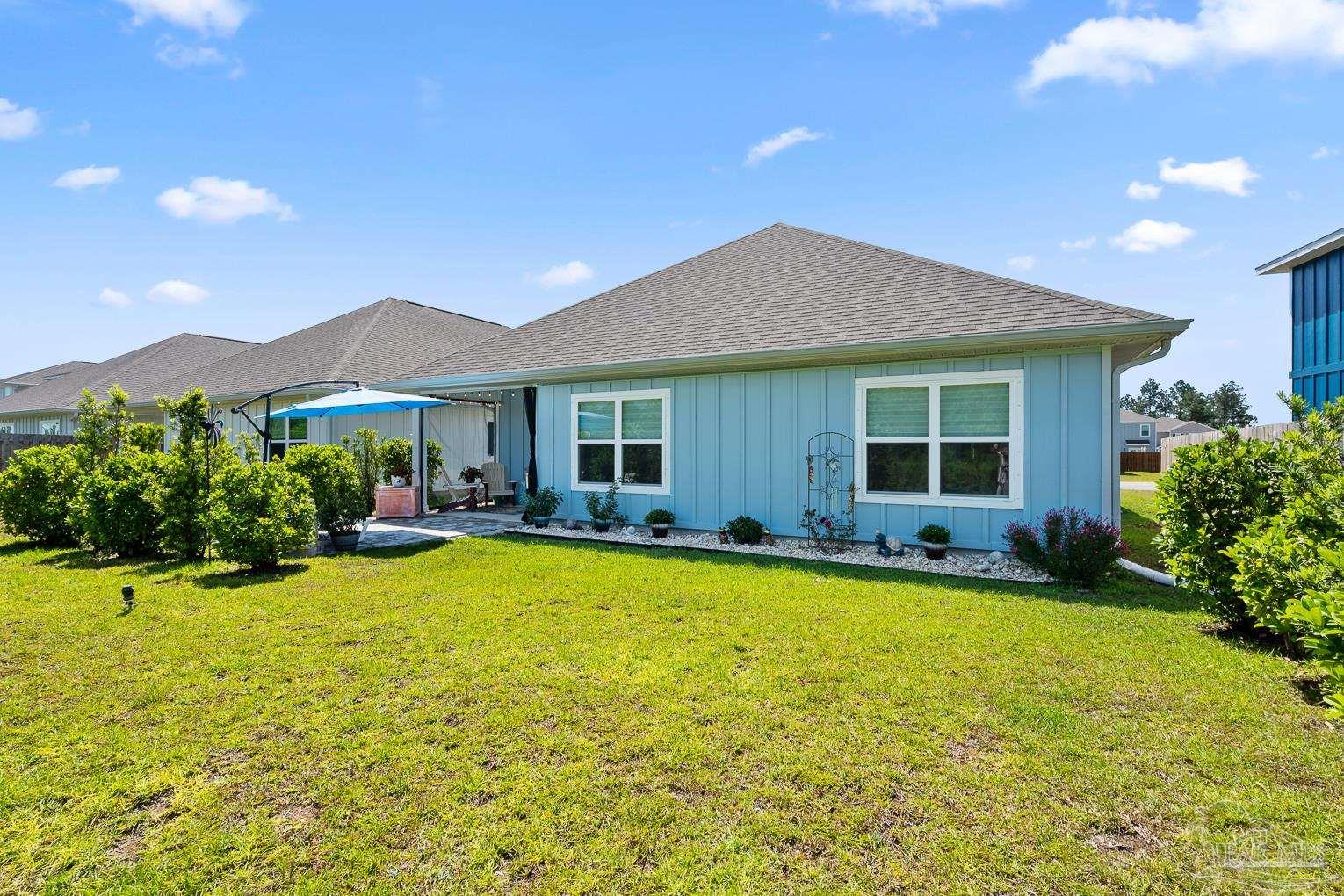 5773 Danbury Boulevard Pace, FL 32571 - Photo 32 of 34 a view of a house with swimming pool and a yard