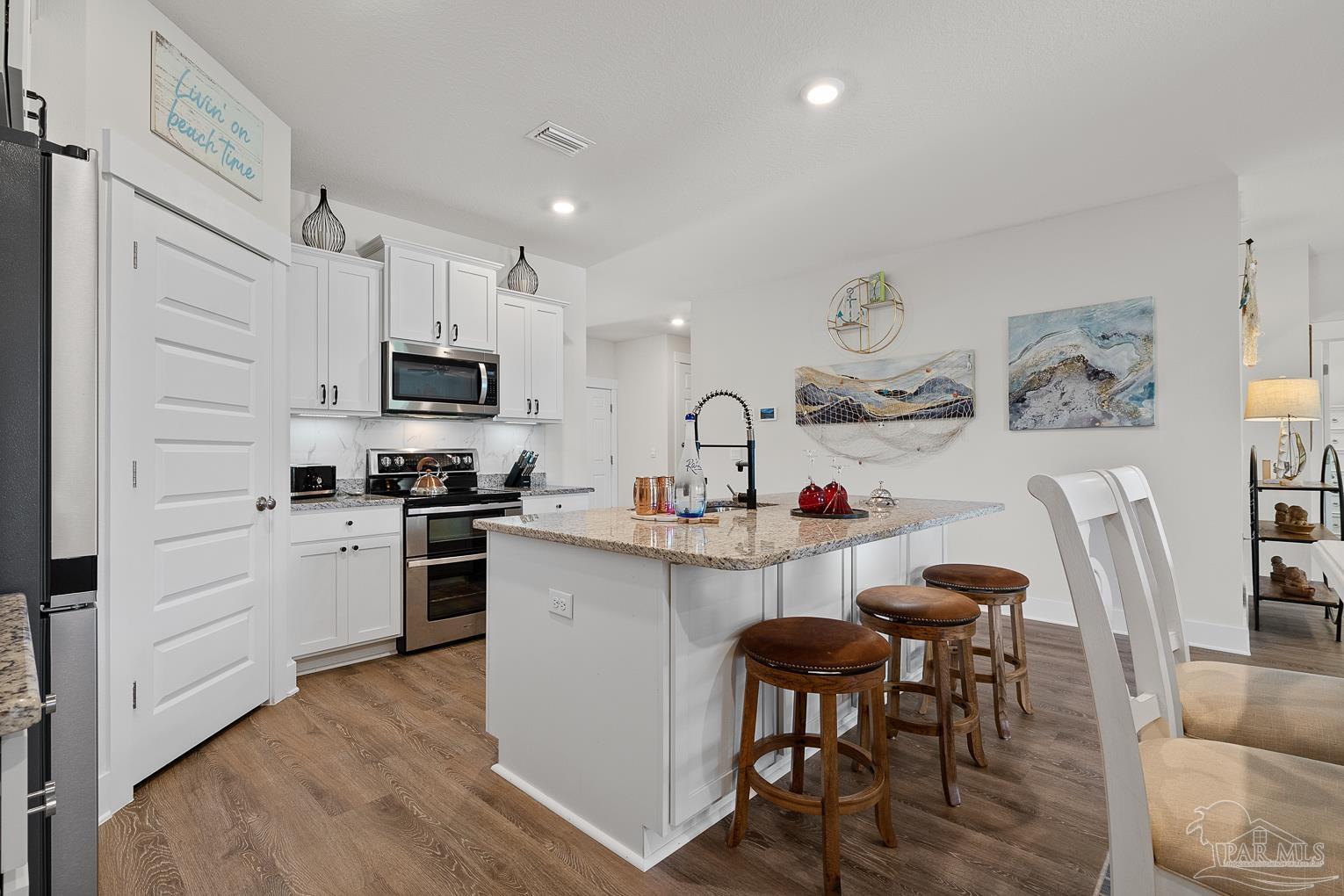 5773 Danbury Boulevard Pace, FL 32571 - Photo 9 of 34 a kitchen with white cabinets and stainless steel appliances