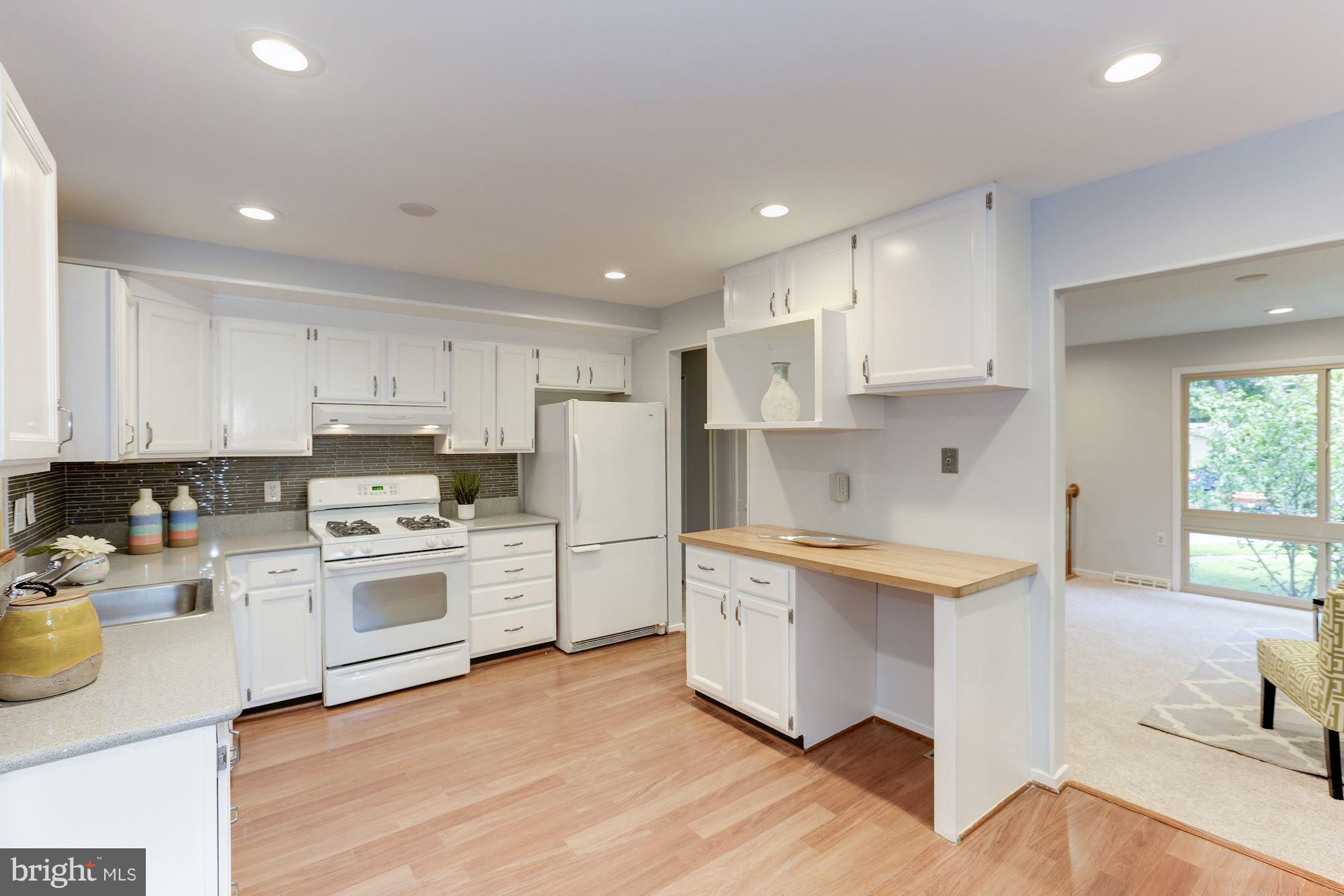 11570 Embers Court Reston, VA 20191 - Photo 6 of 30 a kitchen with a sink a stove a refrigerator and white cabinets