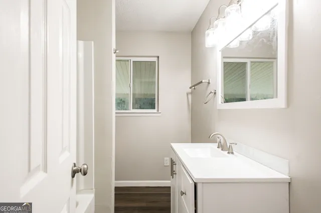 a bathroom with a sink mirror and vanity
