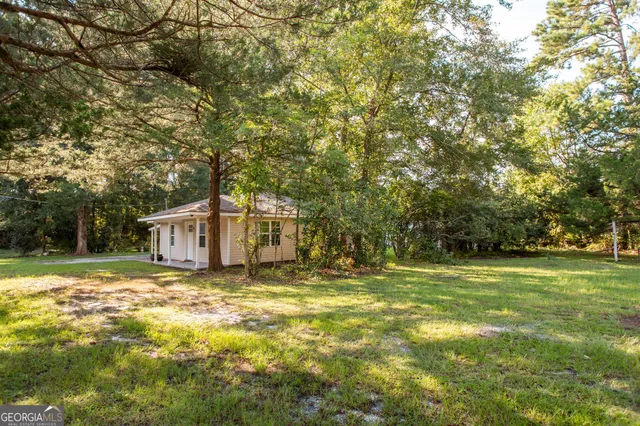 a view of a big yard with large trees