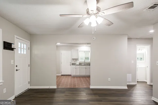 a view of a kitchen with a sink a ceiling fan and wooden floor