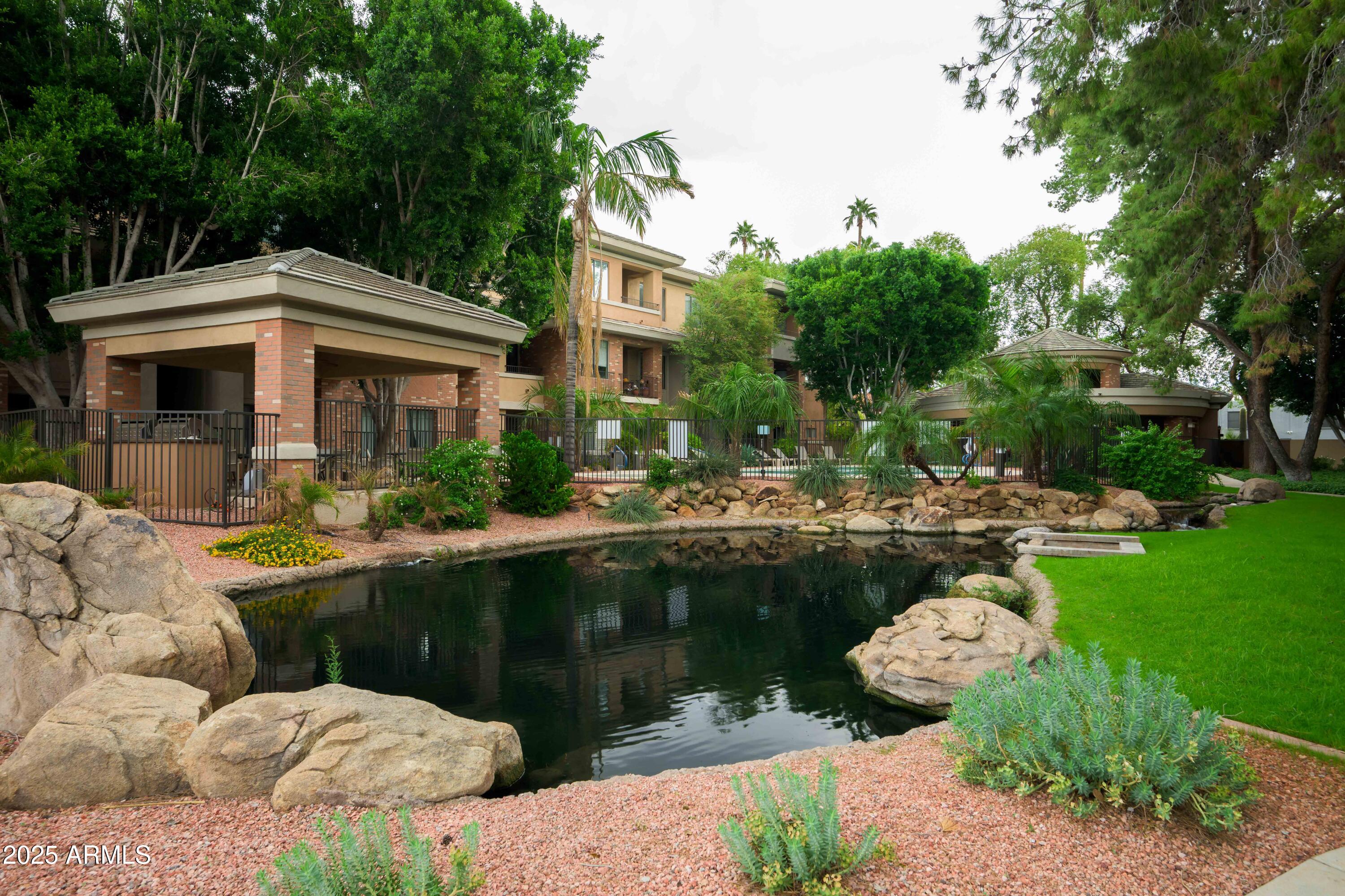 2989 North 44th Street, Unit 2001 Phoenix, AZ 85018 - Photo 25 of 30 a view of a swimming pool with a patio and a garden
