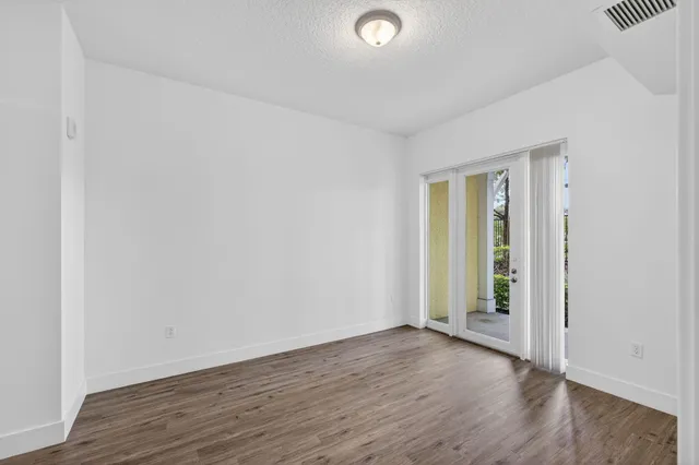 a view of a patio with couches table and chairs under an umbrella